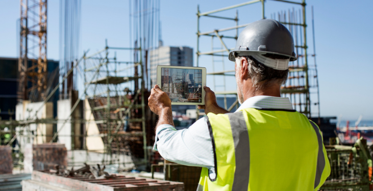 Construction worker captures jobsite photo using iPad.
