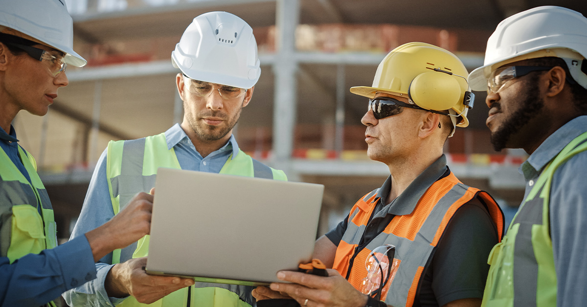 Four workers on the jobsite use digital tools and the Last Planner System