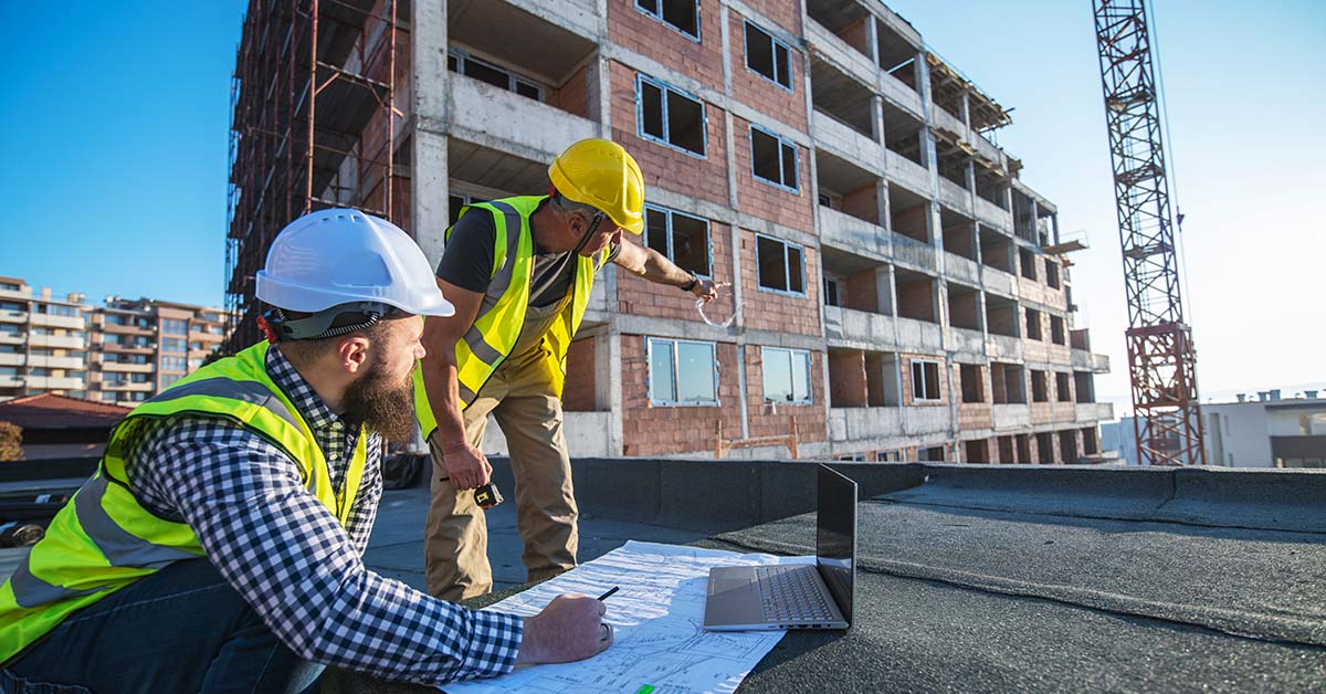Two construction workers on-site, discussing the progress of a project.