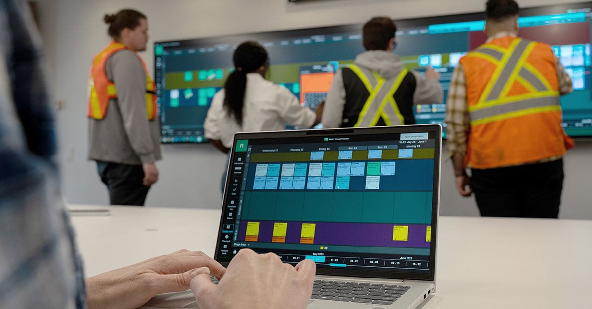 Construction team using Nialli Visual Planner on a laptop and an interactive display.
