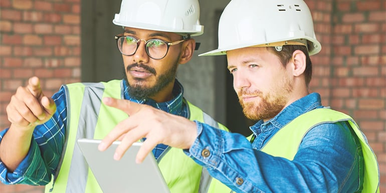 Construction workers on site discussing project details