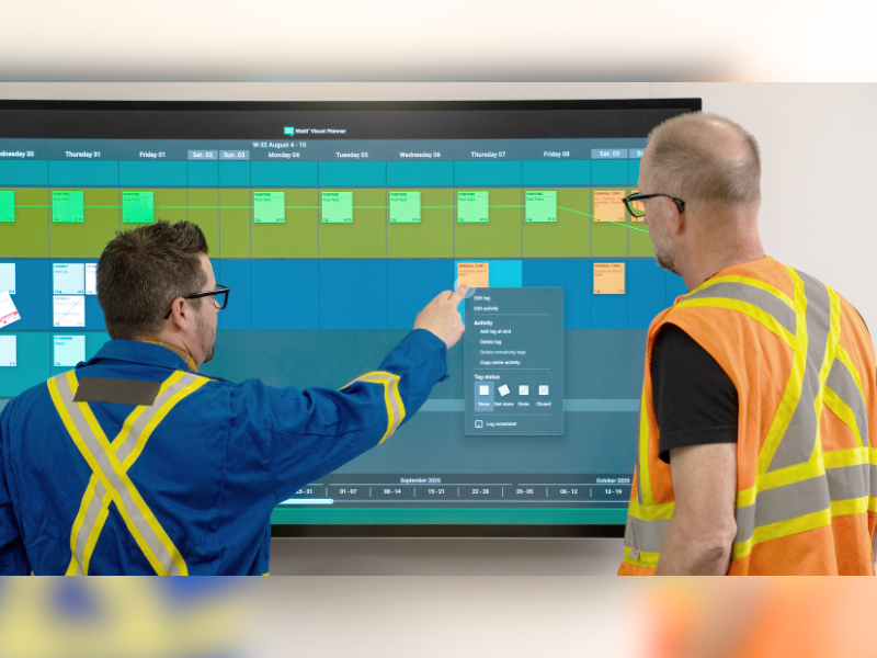 Two construction workers collaborate on an interactive display using Nialli Visual Planner.