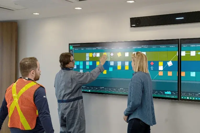 Better conversations - 3 construction workers collaborate using Nialli Visual Planner on an interactive display.